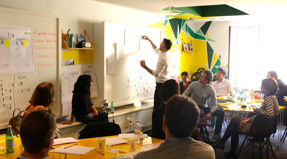 Participants réunis autour de tables de travail lors d'un atelier Klap